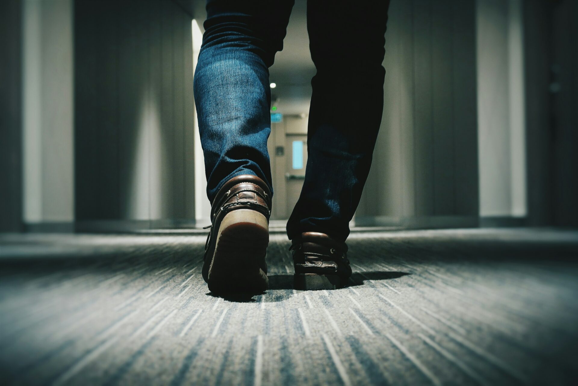 a man with brown sneakers walking on carpet in building.